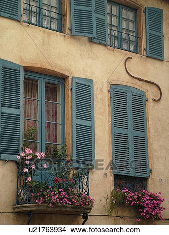 Picture -  France, Chatillon, Ain, Rhone-Alpes, Europe, village, home, windows, windowboxes, pink petunias, blue wooden shutters. Fotosearch