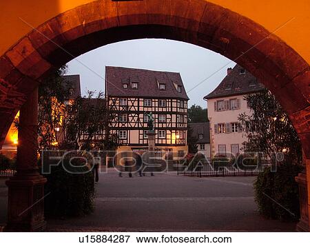 Stock Photo -  France, Europe, Alsace, Colmar, Haut-Rhin, L'Alsace Wine Region, Route du Vin, downtown, evening, half-timbered buildings, archway. Fotosearch