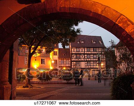 Stock Photo -  France, Europe, Alsace, Colmar, Haut-Rhin, L'Alsace Wine Region, Route du Vin, downtown, evening, half-timbered buildings, archway. Fotosearch
