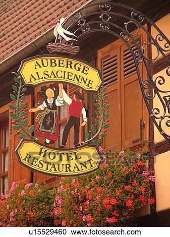 France, Europe, Alsace, Eguisheim, Haut-Rhin, L'Alsace Wine Region, Route du Vin, downtown, hanging sign of dancing Alsaciens and stork outside Auberge Alsacienne View Large Photo Image Stock Image - France, Europe, Alsace, Eguisheim, Haut-Rhin, L'Alsace Wine Region, Route du Vin, downtown, hanging sign of dancing Alsaciens and stork outside Auberge Alsacienne. Fotosearch