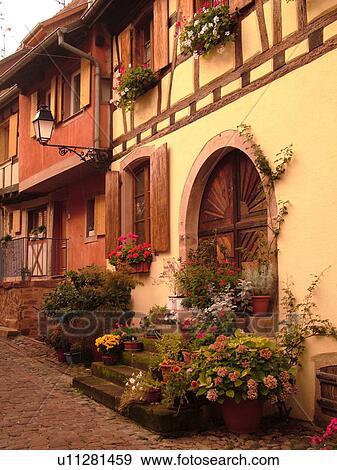 Stock Photo -  France, Europe, Alsace, Eguisheim, Haut-Rhin, L'Alsace Wine Region, Route du Vin, picturesque village, half-timbered buildings, narrow cobblestone pedestrian street. Fotosearch