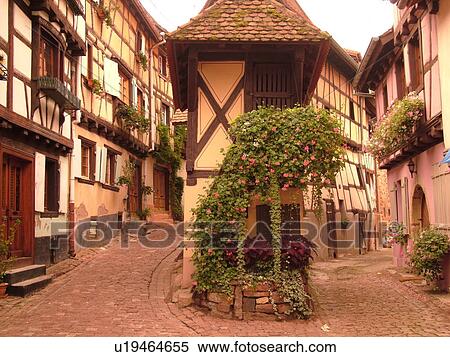 Stock Photography -  France, Europe, Alsace, Eguisheim, Haut-Rhin, L'Alsace Wine Region, Route du Vin, picturesque village, half-timbered buildings, narrow cobblestone pedestrian street. Fotosearch