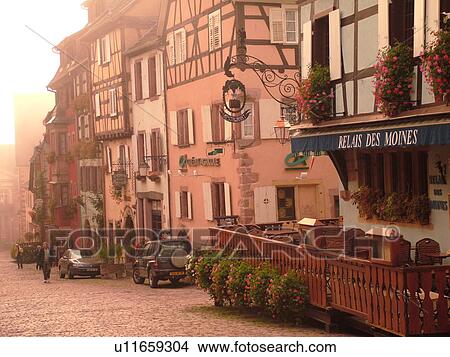 Picture -  France, Europe, Alsace, Riquewihr, Haut-Rhin, L'Alsace Wine Region, Route du Vin, downtown, half-timbered buildings, cobblestone street, fog. Fotosearch