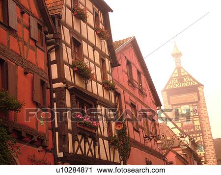 Stock Image -  France, Europe, Alsace, Riquewihr, Haut-Rhin, L'Alsace Wine Region, Route du Vin, downtown, half-timbered buildings, fog. Fotosearch
