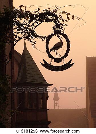 France, Europe, Alsace, Riquewihr, Haut-Rhin, L'Alsace Wine Region, Route du Vin, downtown, silhouette of a stork, hanging store sign, symbol of good fortune View Large Photo Image Stock Image - France, Europe, Alsace, Riquewihr, Haut-Rhin, L'Alsace Wine Region, Route du Vin, downtown, silhouette of a stork, hanging store sign, symbol of good fortune. Fotosearch
