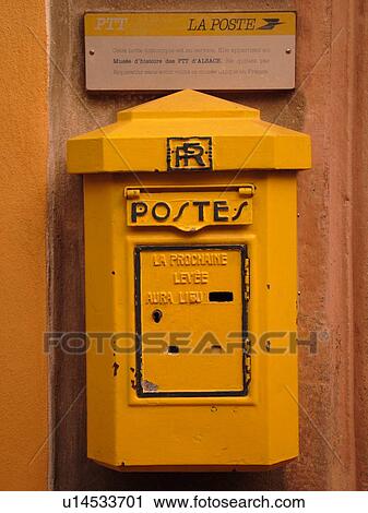 Stock Image -  France, Europe, Alsace, Riquewihr, Haut-Rhin, L'Alsace Wine Region, Route du Vin, postes, yellow mailbox, close-up. Fotosearch