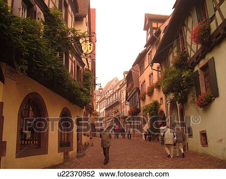 Stock Image -  France, Europe, Alsace, Riquewihr, Haut-Rhin, L'Alsace Wine Region, Route du Vin, downtown, cobblestone pedestrian street, half-timbered buildings. Fotosearch