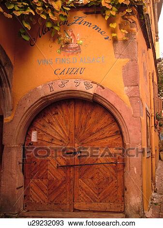Stock Image -  France, Europe, Alsace, Riquewihr, Haut-Rhin, L'Alsace Wine Region, Route du Vin, old wooden arched door, caveau, winery, wine tasting. Fotosearch