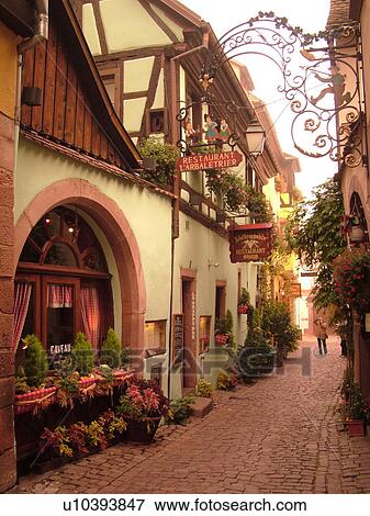 France, Europe, Alsace, Riquewihr, Haut-Rhin, L'Alsace Wine Region, Route du Vin, Restaurants, downtown, half-timbered buildings, narrow cobblestone street View Large Photo Image Stock Photo - France, Europe, Alsace, Riquewihr, Haut-Rhin, L'Alsace Wine Region, Route du Vin, Restaurants, downtown, half-timbered buildings, narrow cobblestone street. Fotosearch