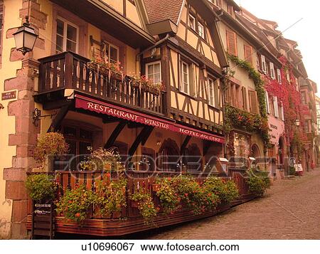 Stock Photo -  France, Europe, Alsace, Riquewihr, Haut-Rhin, L'Alsace Wine Region, Route du Vin, Hotel Restaurant, downtown, half-timbered buildings. Fotosearch
