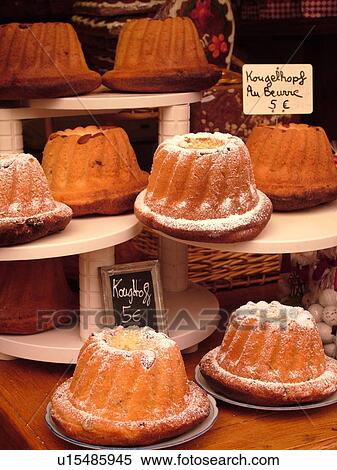 Stock Photography -  France, Europe, Alsace, Riquewihr, Haut-Rhin, L'Alsace Wine Region, Route du Vin, display of traditional Kougelhopf cakes for sale. Fotosearch