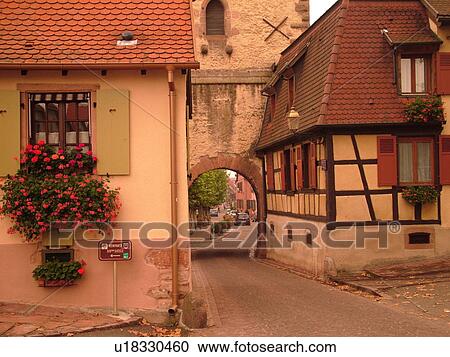 Stock Image -  France, Europe, Alsace, St-Hippolyte, Haut-Rhin, L'Alsace Wine Region, Route du Vin, village, half-timbered building, gate. Fotosearch