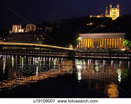 Stock Photo -  France, Lyon, Rhone-Alpes, Europe, Palais de Justice, Saone River, Basilique Notre-Dame de Fourviere, evening, illuminated. Fotosearch