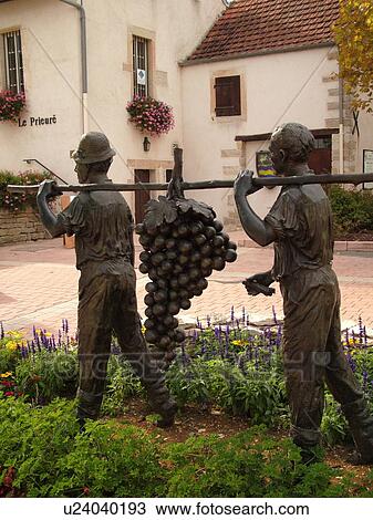 Stock Image -  France, Marsannay la Cote, Burgundy, Cote de Nuits, Cote d'Or, Europe, Burgundy Wine Region, wine harvest statue, men carrying grapes. Fotosearch