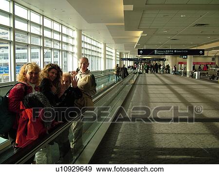 Stock Photo -  Minneapolis, MN, Minnesota, Minneapolis International Airport, family on moving sidewalk, airport terminal, hub. Fotosearch