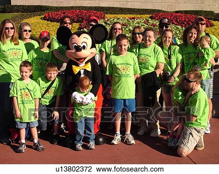 Stock Image -  Orlando, FL, Florida, Walt Disney World Resort, Magic Kingdom Park, Minnie Mouse poses with group of people for pictures (Editorial Use Only). Fotosearch
