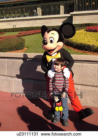 Stock Image -  Orlando, FL, Florida, Walt Disney World Resort, Magic Kingdom Park, Mickey Mouse poses with little boy for pictures (Editorial Use Only). Fotosearch