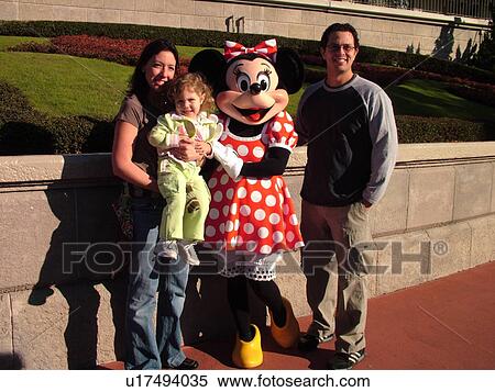 Stock Photography -  Orlando, FL, Florida, Walt Disney World Resort, Magic Kingdom Park, Minnie Mouse poses with a family for pictures (Editorial Use Only). Fotosearch