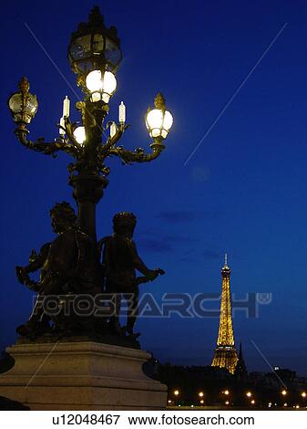 Stock Photo -  Paris, France, Europe, Ile de France, Pont Alexandre III, Sculpture, Lamppost, Eiffel Tower in background, evening. Fotosearch