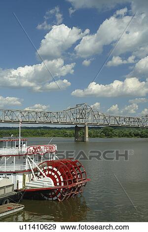 Stock Photo -  Peoria, IL, Illinois, Illinois River, Riverfront, Paddle Wheeler, Spirit of Peoria, riverboat, Murray Baker Bridge. Fotosearch