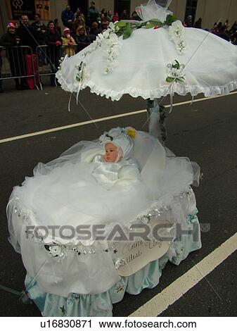 Stock Image -  Philadelphia, PA, Pennsylvania, downtown, New Years Day, Philadelphia Annual Mummer's Day Parade, 2006, Comic Division, Anne Geddes Littlest Angel, baby in bassinet with umbrella. Fotosearch