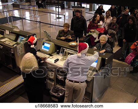 Stock Image -  Philadelphia, PA, Pennsylvania, Philadelphia International Airport, check-in, airport terminal, ticket counter, santa hats, seasonal. Fotosearch