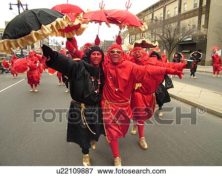 Stock Photo -  Philadelphia, PA, Pennsylvania, downtown, New Years Day, Philadelphia Annual Mummer's Day Parade, 2006, Comic Division, men in red and black dresses with umbrellas, satan, devils. Fotosearch