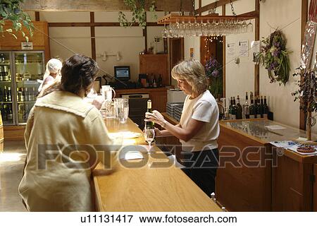 Stock Photo -  Romulus, NY, New York, Finger Lakes, Swedish Hill Winery, wine tasting. Fotosearch