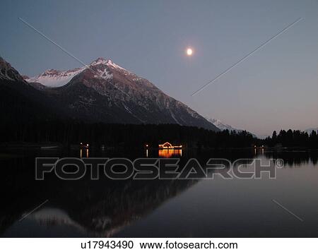 Stock Image -  Switzerland, Europe, Lenzereide, Valbella, Heidsee, Graubunden, Grisons, moonrise, mountain lake, reflection, evening. Fotosearch