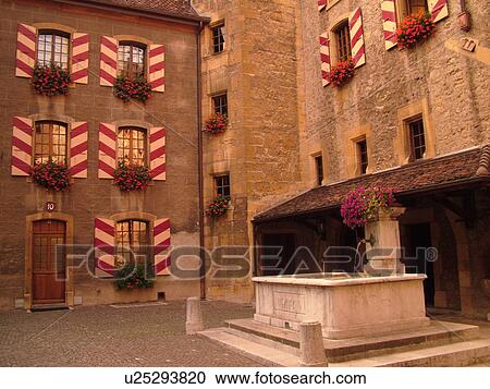Stock Image -  Switzerland, Europe, Neuchatel, Chateau Neuchatel, 15th century castle, red geraniums in windowboxes, red and white striped shutters. Fotosearch
