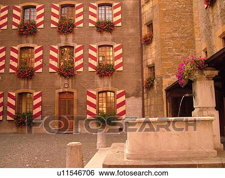 Stock Photograph -  Switzerland, Europe, Neuchatel, Chateau Neuchatel, 15th century castle, red geraniums in windowboxes, red and white striped shutters, fountain. Fotosearch