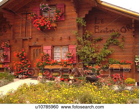 Stock Image -  Switzerland, Europe, valais, wallis, Val d'Anniviers, Grimentz, old chalet adorned with red geraniums. Fotosearch