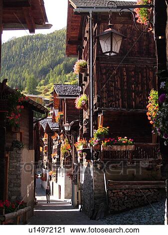 Switzerland, Europe, valais, wallis, Val d'Anniviers, Grimentz, old chalets along a narrow pedestrian street View Large Photo Image Stock Image - Switzerland, Europe, valais, wallis, Val d'Anniviers, Grimentz, old chalets along a narrow pedestrian street. Fotosearch