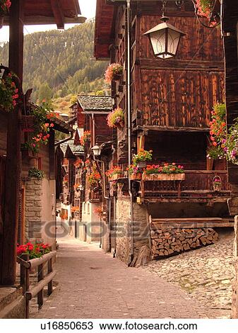 Stock Image -  Switzerland, Europe, valais, wallis, Val d'Anniviers, Grimentz, old chalets along a narrow pedestrian street. Fotosearch