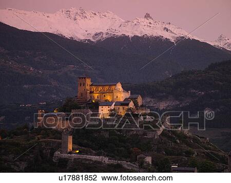 Stock Image -  Switzerland, Europe, valais, wallis, Sion, Rhone Valley, Fendant Wine Region, Church of Notre Dame de ValFre, 11th century, ChGteau de Tourbillon, sunset, alps. Fotosearch