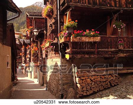 Stock Image -  Switzerland, Europe, valais, wallis, Val d'Anniviers, Grimentz, old chalets along a narrow pedestrian street. Fotosearch