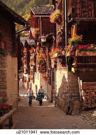 Stock Image -  Switzerland, Europe, valais, wallis, Val d'Anniviers, Grimentz, old chalets along a narrow pedestrian street. Fotosearch