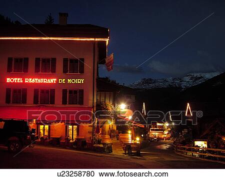 Stock Image -  Switzerland, Europe, valais, wallis, Val d'Anniviers, Grimentz, alpine village, Hotel Restaurant De Moiry, outdoor cafT, evening. Fotosearch
