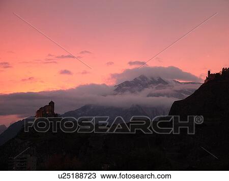 Stock Image -  Switzerland, Europe, valais, wallis, Sion, Rhone Valley, Fendant Wine Region, Church of Notre Dame de ValFre, 11th century, ChGteau de Tourbillon, sunset, alps. Fotosearch