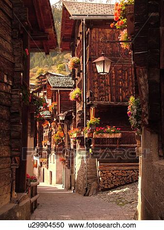 Stock Image -  Switzerland, Europe, valais, wallis, Val d'Anniviers, Grimentz, old chalets along a narrow pedestrian street. Fotosearch