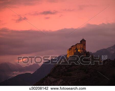 Stock Image -  Switzerland, Europe, valais, wallis, Sion, Rhone Valley, Fendant Wine Region, Church of Notre Dame de ValFre, 11th century, sunset, alps. Fotosearch