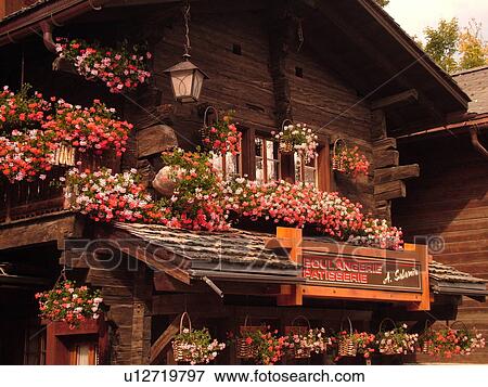 Stock Photo -  Switzerland, Europe, valais, wallis, Val d'Anniviers, Grimentz, chalet, Boulangerie, Patisserie decorated with pink and red geraniums, close-up. Fotosearch