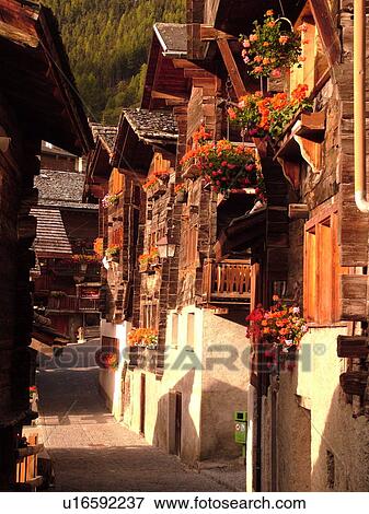 Switzerland, Europe, valais, wallis, Val d'Anniviers, Grimentz, old wooden chalets along a narrow pedestrian street decorated with flowers View Large Photo Image Stock Photo - Switzerland, Europe, valais, wallis, Val d'Anniviers, Grimentz, old wooden chalets along a narrow pedestrian street decorated with flowers. Fotosearch