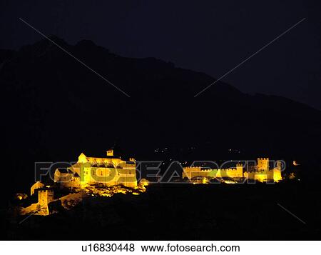 Stock Photo -  Switzerland, Europe, valais, wallis, Sion, Rhone Valley, Fendant Wine Region, Church of Notre Dame de ValFre, 11th century, ChGteau de Tourbillon, illuminated, evening, alps. Fotosearch