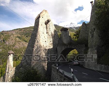 Stock Photo -  Switzerland, Europe, valais, wallis, Val D'Herens, Pyramides, earth pillars, columns, mountain road, tunnel. Fotosearch