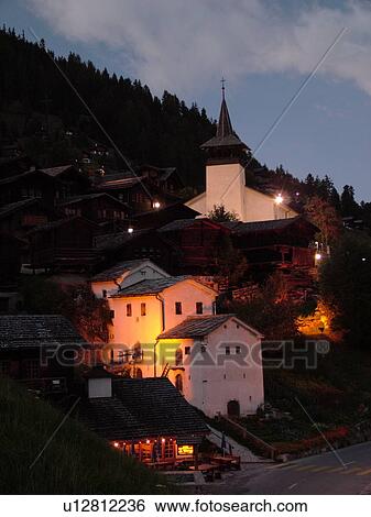 Stock Photograph -  Switzerland, Europe, valais, wallis, Val d'Anniviers, Grimentz, alpine village, church, evening, illuminated. Fotosearch