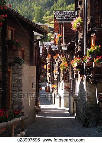 Stock Photograph -  Switzerland, Europe, valais, wallis, Val d'Anniviers, Grimentz, old chalets along a narrow pedestrian street. Fotosearch
