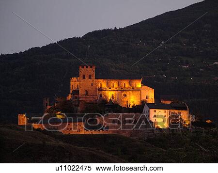 Stock Photography -  Switzerland, Europe, valais, wallis, Sion, Rhone Valley, Fendant Wine Region, Church of Notre Dame de ValFre, 11th century, illuminated, evening, alps. Fotosearch