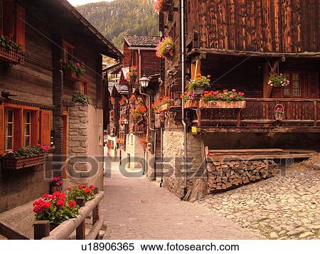 Switzerland, Europe, valais, wallis, Val d'Anniviers, Grimentz, old chalets along a narrow pedestrian street View Large Photo Image Stock Photography - Switzerland, Europe, valais, wallis, Val d'Anniviers, Grimentz, old chalets along a narrow pedestrian street. Fotosearch