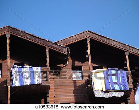 Stock Photography -  Switzerland, Europe, valais, wallis, Val d'Anniviers, Grimentz, airing out duvets, hang over balcony railings. Fotosearch